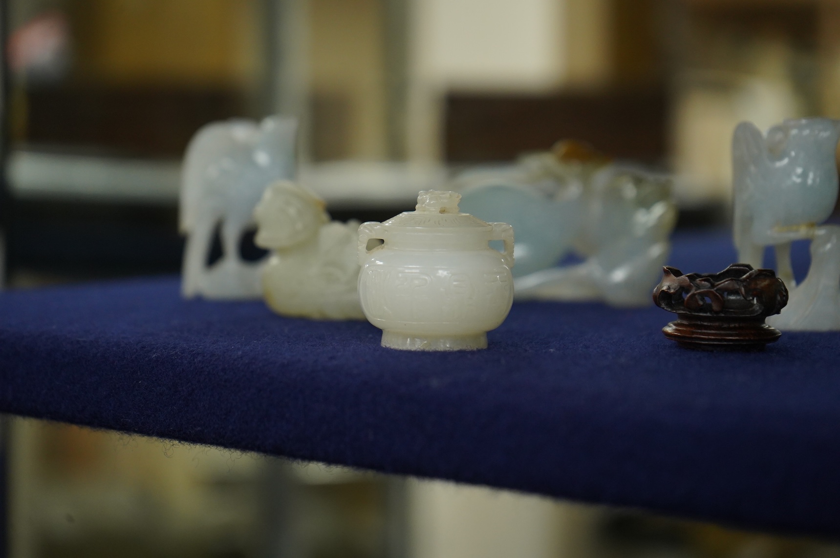 A Chinese jade figure of a Mandarin duck and a miniature pot and cover, three jadeite carvings and a bowenite dragon, 16.5cm
